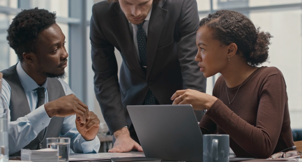 Attorneys discussing case details around a laptop